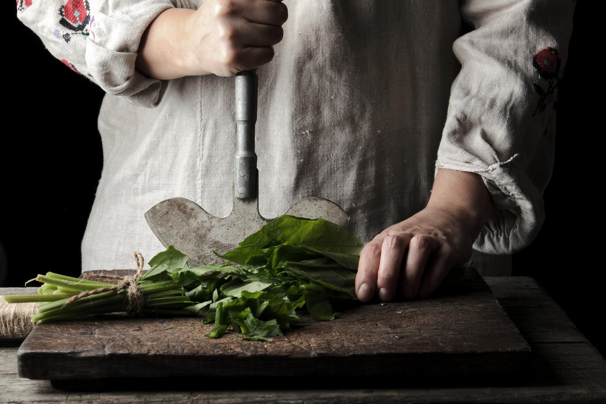 Artisan chef arranging herbs in rustic kitchen